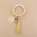 Portachiavi con bracciale di perline in silicone, ciondolo in legno inciso e nappa chic. - Nudo