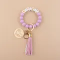 Portachiavi braccialetto in perline di silicone con ciondolo a cuore in legno e nappa. - Viola chiaro