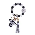Close-up of cow print silicone bead keychain with tassel and Mama pendant on white background - Lake