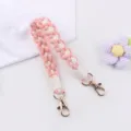 Handmade woven cup strap in pink and white with gold clasps, perfect for water bottles and bags. - Pink