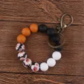 Silicone beaded wristlet keychain with printed floral beads and vintage metal clasp. - Brown