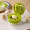 Close-up detail of a manual green garlic press featuring a stainless steel dicing grid - Small Garlic Graters