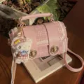 Sac à bandoulière en tweed rose avec pendentif en peluche et fermoir en métal élégant. - Avec Pendentif / Rose