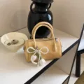 Yellow women's pillow bag with pearl tulip pendant, stylish leather handbag for commute. - With Charm / Yellow