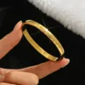 Close-up detail of the faceted 18k gold color titanium steel bangle with sparkling rhombus cuts. - 6mm Width / Gold
