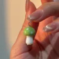 Primer plano detallado de un lindo dije colgante de seta verde y blanca con anilla plateada. - Estilo A (1DZ69-SG)