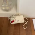 Sac bandoulière beige avec pendentif cerise, sac à main tendance pour femme chic. - Avec Pendentif / Blanc