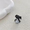 Primer plano detallado de un abalorio de animal de vidrio blanco y negro, ideal para joyas. - Perro Negro