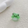 Close-up detail of a cute green frog glass bead, perfect for DIY handmade jewelry crafts. - Frog
