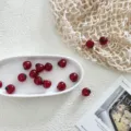 Detailed view of red glass cherry fruit DIY beads accessories for handmade jewelry design. - Apple Red