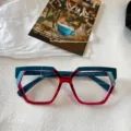 Vista detallada de la montura de gafas cuadrada irregular colorida y de moda para mujeres. - Verde Transparente Superior Y Rojo Transparente Inferior