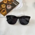 Primer plano detallado de elegantes gafas de sol cuadradas negras con protección UV. - Negro