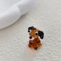 Primer plano de una bonita cuenta de animal cachorro de vidrio marrón para joyería de bricolaje. - Perro Sentado