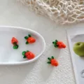 Close-up detail of handmade fruit glass beads for DIY jewelry making, colorful and glossy. - Raspberry