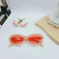 Vista detallada de gafas de sol ovales de moda con montura rosa elegante y lentes rojas. - Rosa Gelatina