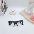 Detail shot of trendy black cat-eye blue light blocking glasses with stylish half-frame design. - Sand Black / Clear Lens