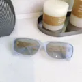Graue rechteckige Sonnenbrille mit eleganten goldenen Kettendetails für modischen Alltagsstil. - Gelee-Blau