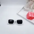Close-up of trendy white rectangular sunglasses with black lenses for stylish street fashion. - White Frame Grey Lens