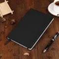 A5 black hardcover notebook with elastic closure band and ribbon bookmark for daily journaling. - A5-80 Sheets (145*210mm) / Black