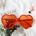 Lunettes de soleil rouges en forme de cœur avec verres teintés orange, style tendance. - Rouge