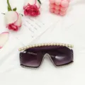 Gros plan sur les lunettes de soleil sans monture avec perles sur le bord et strass scintillants. - Blanc