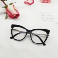 Vista detallada de la montura de gafas cat-eye negra con elegantes patillas de metal. - Negro