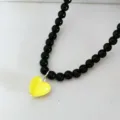 Schwarze Perlenkette mit gelbem Herz-Anhänger für Damen, stilvolles Modeschmuck-Accessoire. - Schwarze Kette Gelbes Herz