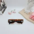 Detalle de gafas de sol retro de montura pequeña con estampado de leopardo, accesorio de moda. - Estampado de leopardo