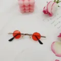 Primer plano de gafas de sol redondas punk retro con cristales rojos sobre fondo blanco. - Rojo