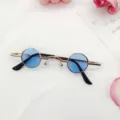 Vista detallada de gafas de sol redondas retro punk con montura metálica dorada y lentes azules. - Azul