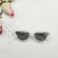 Primer plano de elegantes gafas de sol blancas estilo cat-eye con lentes oscuras. - Montura Blanca Gris Claro
