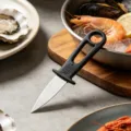Stainless steel oyster shucking knife with black handle for seafood, clams and scallops. - Standard Type