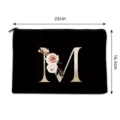 Black canvas cosmetic bag with gold letter M and floral print, portable travel makeup pouch. - Letter M