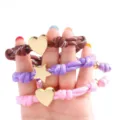 Primer plano detallado de pulseras de cuerda trenzada colorida con dijes dorados. - Estilo Estrella
