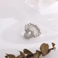 Primer plano detallado del deslumbrante anillo de corazón con circonitas en tono plateado. - Letra D