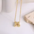 Vue détaillée d'un collier pendentif lettre M en or, avec chaîne délicate et finition brillante. - Lettre M
