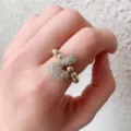Detailed view of fashion copper micro-set zircon letter ring with 18k gold plating on hand. - L