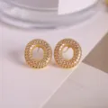 Elegant gold-plated circular micro-paved cubic zirconia stud earrings for women. - Letter O