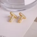 Elegant gold letter T stud earrings paved with sparkling cubic zirconia for women and men. - Letter T
