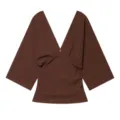 Detailed view of the brown deep V-neck short sleeve top with pleated front design. - S / Tops / Brown