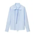 Dettaglio in primo piano dell'elegante camicia a maniche lunghe a righe blu e bianche con fiocco. - Taglia S / Strisce blu e bianche