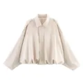 Close-up detail of women's beige batwing sleeve jacket, stylish loose spring outerwear fabric. - Off White