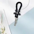 Vue détaillée de la lanière de téléphone fleur noire, accessoire mignon et minimaliste avec fermoir. - Noir