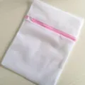 Sac à linge en filet blanc avec fermeture éclair rose pour le lavage délicat vue détaillée. - Maille fine avec bordure