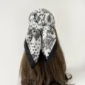 Black and white paisley print square scarf detail showing the elegant tied bandana styling. - Patchwork Paisley