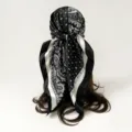 Detail view of black and white paisley and polka dot silk scarf worn as a stylish head wrap. - D9506 - Black