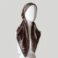 Nahaufnahme des Leopardenmuster-Satin-Kopftuchs zeigt glatte Textur und klassisches Design. - Dunkelbraun