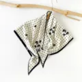 Close-up view of a chic polka dot floral triangular silk scarf featuring elegant black and white design. - Floral Polka Dot(SJJ023) / Beige