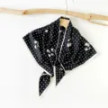 Detailed shot of a black and white polka dot triangular scarf hanging on a rustic wooden hanger. - Floral Polka Dot(SJJ023) / Black