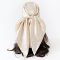 Detail view of the elegant beige paisley satin square scarf, showcasing smooth draping effect. - Khaki
